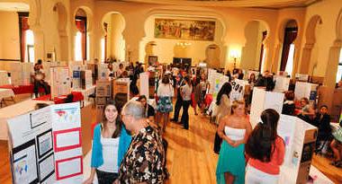 Students showing research posters at event